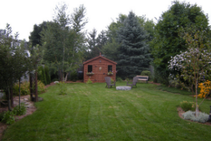 Finished backyard with nice landscaping. A shed is in the middle with some chairs around a fire-pit. (© LEAF 2010)