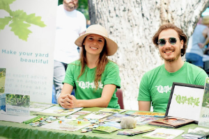 Volunteers sitting behind an outreach table(© 2018 Kanchan Maharaj)