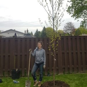 LEAF Planter with shovel by newly planted tree(© 2019 Brenna Anstett / LEAF)