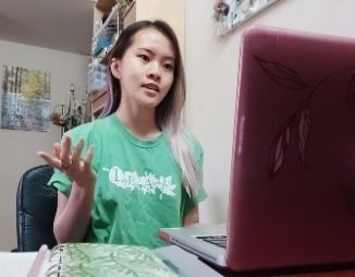 Young woman sitting in front of a computer monitor presenting