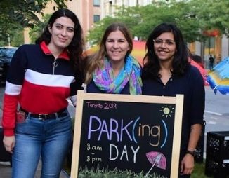 Young women by sign, "Park(ing) Day"