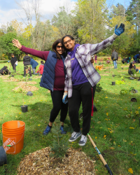 two LEAF volunteers posing with a newly planted tree