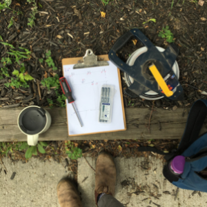 Birdseye view photo of landscape architecture tools. Includes a measuring tape and a sighting map with pens and pencils. (© 2017 Kaja McDonald - LEAF)