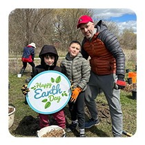 Volunteers holding an Earth Day sign at Budweth Park community planting event. (© 2024 Mikahail Lewis / LEAF)