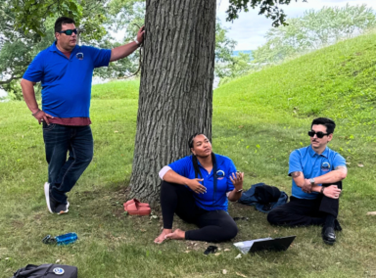 Gary Pritchard and 4 Directions staff leading a workshop, outside under a tree