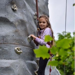 Young girl climbing on the rock wall